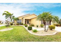 Charming single-story home featuring a well-manicured lawn, lush landscaping, and mature palm trees creating great curb appeal at 24321 Kintail Ct, Punta Gorda, FL 33980