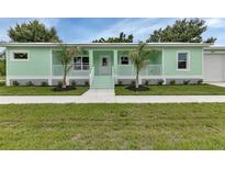 Charming mint green home with well-maintained lawn and beautiful landscaping at 535 Milus St, Punta Gorda, FL 33950
