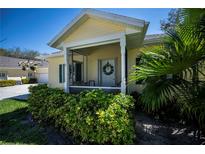 Charming home entrance with screened-in porch and lush landscaping in a sunny neighborhood at 1420 Winding Oak Dr, Port Charlotte, FL 33948