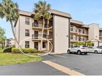 Multi-story condo building boasts balconies, parking and lush landscaping with mature palm trees on a sunny day at 1999 Kings Hwy # 21A, Punta Gorda, FL 33980