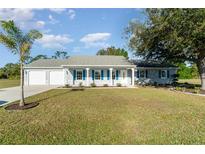 Charming single-story home featuring a well-maintained lawn, two-car garage, and a welcoming front porch at 25413 Prada Dr, Punta Gorda, FL 33955