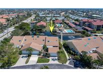Aerial view of the townhouse complex featuring water features, swimming pool, red tile roofs and tropical landscaping at 2645 W Marion Ave # 114, Punta Gorda, FL 33950
