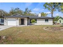 Charming single-story home featuring well-kept lawn, garage, and neutral siding under a blue sky at 3956 Fairchild Ave, North Port, FL 34287