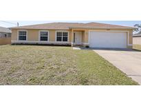 Inviting single-story home featuring a well-maintained lawn, attached garage, and neutral color palette at 4237 Irdell Ter, North Port, FL 34288