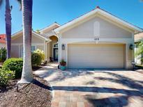 Charming single-story home with a brick driveway, two-car garage, and well-maintained landscaping at 629 Misty Pine Dr, Venice, FL 34292