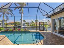 Screened in pool with waterfront views, brick paver deck and access to the canal in this beautiful home at 3812 Carupano Ct, Punta Gorda, FL 33950