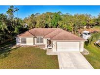 Well-maintained single-story home with a lush green lawn and an attached two-car garage at 4221 Circleville St, North Port, FL 34286