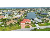 Beautiful waterfront home boasts a red tile roof, an attached two-car garage, and well-kept landscaping at 480 Macedonia Dr, Punta Gorda, FL 33950