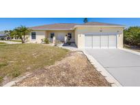Charming single-story home with a well-manicured lawn, attached garage, and a welcoming facade at 7014 Baylor Street, Englewood, FL 34224