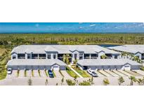 An aerial view of condo buildings showing a tranquil water view and attached garages with a paver driveway at 14281 Heritage Landing Blvd # 1411, Punta Gorda, FL 33955