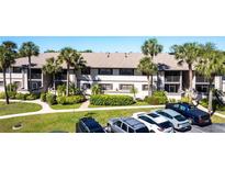 Condominium with palm trees, landscaped yard, and ample parking spaces at 1515 Forrest Nelson Blvd # L204, Port Charlotte, FL 33952