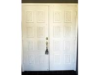 Elegant white double front door with decorative raised panels and secure lock at 3309 Conway Blvd, Port Charlotte, FL 33952