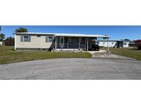 Charming mobile home with a carport and small front porch and decorative pink flamingos at 6821 Ocean Ct # Lot 30, North Port, FL 34287