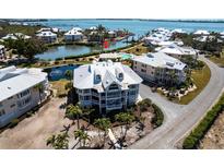 Stunning aerial view of a condo surrounded by water, lush landscaping, and community amenities at 11000 Placida Rd # 1501, Placida, FL 33946