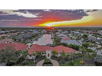 Stunning aerial view of a waterfront home at sunset, boasting a tile roof, lush landscaping, and canal access at 1111 San Mateo Dr, Punta Gorda, FL 33950