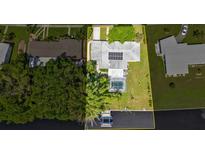 Aerial view of the property highlighting the pool, boat dock, and solar panels on the roof at 131 Buckeye Nw Ave, Port Charlotte, FL 33952