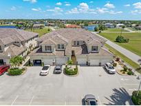 Stunning aerial view of townhomes boasting tile roofs, attached garages, and convenient parking, surrounded by lush landscaping at 17094 Acapulco Rd # 312, Punta Gorda, FL 33955