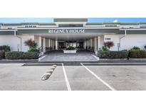 Welcoming entrance to Regency House with covered drive, well-maintained landscaping, and ample parking at 2300 Aaron St # 106, Port Charlotte, FL 33952