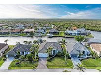 Stunning aerial view of waterfront homes on a canal, showcasing lush landscaping and private boat docks at 333 Santander Ct, Punta Gorda, FL 33950