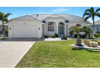 Charming single-story home featuring a lush green lawn and well-manicured landscaping, offering curb appeal at 609 Macedonia Dr, Punta Gorda, FL 33950