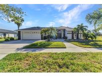 Charming home with a well-manicured lawn, lush landscaping, and a two-car garage at 1068 Harbour Cape Pl, Punta Gorda, FL 33983