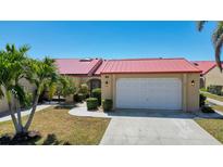 Charming single-story home featuring a red roof, well-manicured lawn, and attached garage, perfect for comfortable living at 1780 Deborah Dr # 25, Punta Gorda, FL 33950