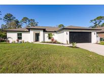 Charming single-story home with a well-manicured lawn and modern black trim at 18124 Goliad Ave, Port Charlotte, FL 33954