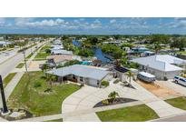 Waterfront property featuring mature landscaping, circular driveway, and boat parking in a quiet neighborhood at 21194 Edgewater Dr, Port Charlotte, FL 33952