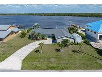 Expansive aerial view of a waterfront property, featuring lush landscaping and a private dock against a serene water backdrop at 2308 Harbour Dr, Punta Gorda, FL 33983