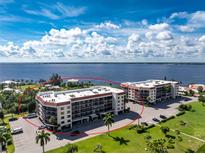 Waterfront condo complex boasting lush landscaping and ample parking under a blue sky at 25188 Marion Ave # E409, Punta Gorda, FL 33950
