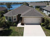 Inviting single-Gathering home with a two-car garage, manicured landscaping, and beautiful lakeside views at 25325 E Lenox Cir, Punta Gorda, FL 33950