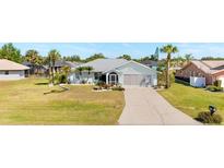 Charming single-story home with a well-manicured lawn, landscaped flowerbeds, and a two-car garage at 25730 Deep Creek Blvd, Punta Gorda, FL 33983