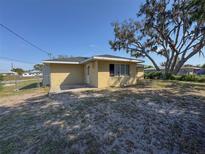 A single-story home featuring a simple design and minimal landscaping with a spacious yard and mature trees at 30147 Holly Rd, Punta Gorda, FL 33982
