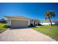 Charming single-story home featuring a brick driveway, two-car garage, and lush lawn at 359 Paramaribo St, Punta Gorda, FL 33983