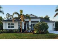 Inviting single-story home with a well-manicured lawn and tropical landscaping at 401 Gold Tree, Punta Gorda, FL 33955