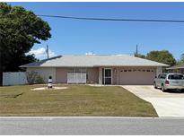 Charming single-story home with well-maintained lawn and a lighthouse decoration at 594 W Tarpon Nw Blvd, Port Charlotte, FL 33952