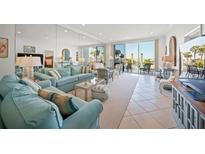 Bright living room with beach views, tile floors, and comfortable seating at 1212 Benjamin Franklin Dr # 102, Sarasota, FL 34236