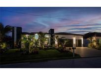 Contemporary home showcasing professional landscaping, a two-car garage, and modern architectural elements at twilight at 1230 Royal Tern Dr, Punta Gorda, FL 33950