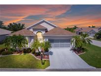 Charming single-story home with well-manicured landscaping and a spacious driveway leading to a two-car garage at 1701 Lastingham Ln, Port Charlotte, FL 33980