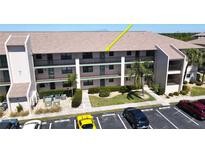 Three-story condo building showcasing parking and tropical landscaping at 175 Kings Hwy # 736, Punta Gorda, FL 33983