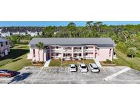 Exterior view of a pink two-story condo building with multiple parking spaces in front at 179 Boundary Blvd # 4, Rotonda West, FL 33947