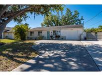 Charming single-story home with a well-maintained lawn, mature tree, and a long driveway leading to a one-car garage at 18417 Ohara Dr, Port Charlotte, FL 33948