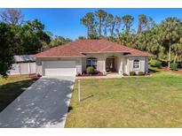 Charming single-story home features a manicured lawn, a two-car garage, and a new roof at 3172 Sikeston Ave, North Port, FL 34286