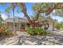 Charming home with lush landscaping, mature trees and a covered front porch at 4074 Redbird Cir, Sarasota, FL 34231