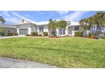 Beautiful home featuring lush lawn, meticulous landscaping, and a well-maintained exterior at 412 Panarea Dr, Punta Gorda, FL 33950