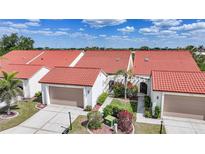 Charming townhomes featuring red tile roofs, inviting walkways, and attached garages at 5036 San Rocco Ct, Punta Gorda, FL 33950