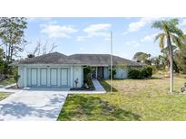 Charming single-story home featuring a spacious three-car garage and well-manicured lawn at 535 Ramblewood St, Port Charlotte, FL 33953