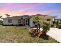 Charming single-story home with well-manicured lawn, landscaped flower beds, and inviting entrance at 145 Brig E Cir, Placida, FL 33946