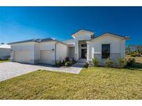 Beautiful home featuring a well-manicured lawn and a three-car garage, providing ample space for vehicles and storage at 17476 Vellum Cir, Punta Gorda, FL 33955
