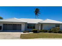 Charming single-story home featuring a white tile roof, attached garage, and well-maintained landscaping at 2350 W Marion Ave, Punta Gorda, FL 33950